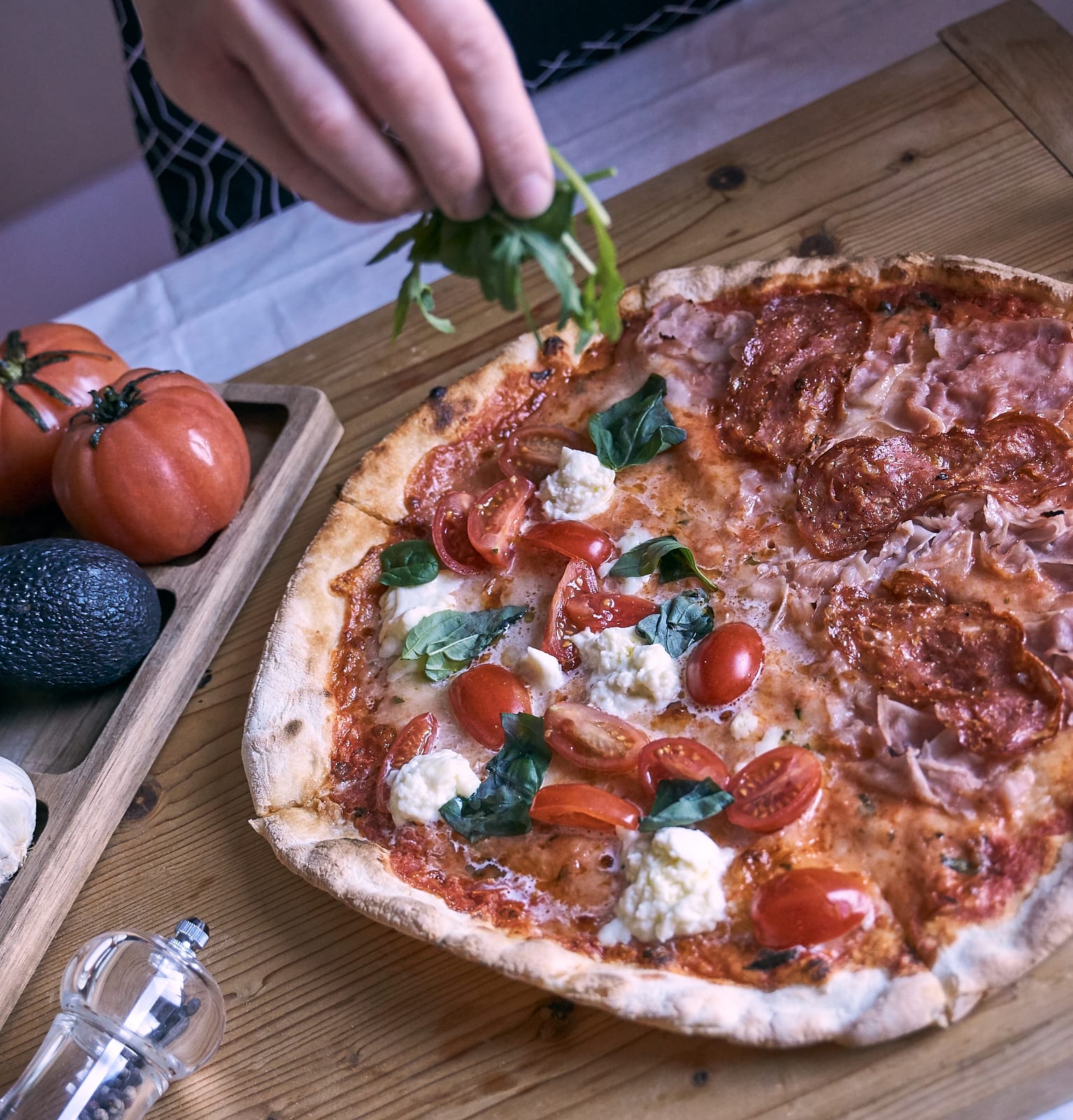 Pizzára rukkolát szór a szakács