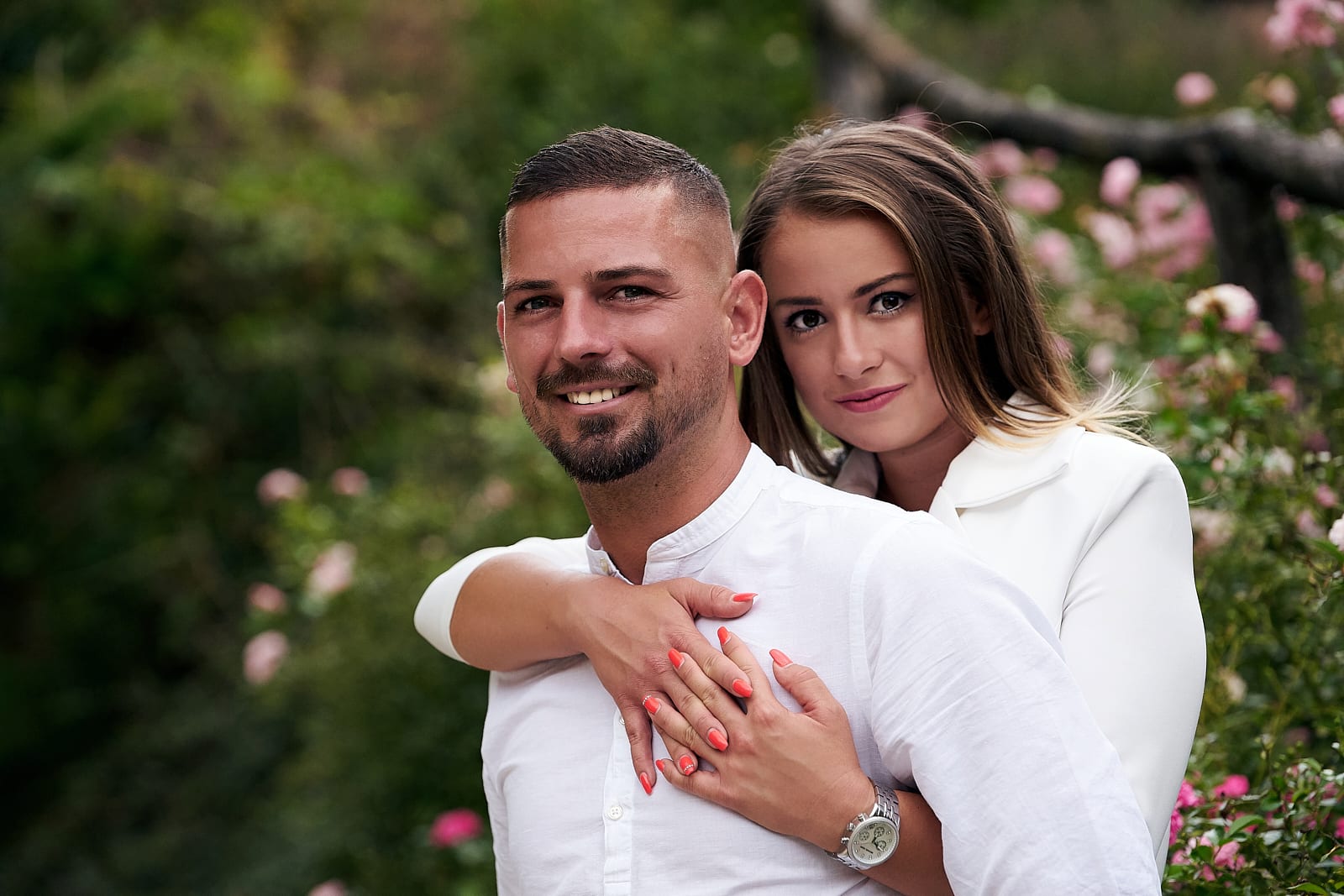 Noémi öleli Gábort a virágok előtt